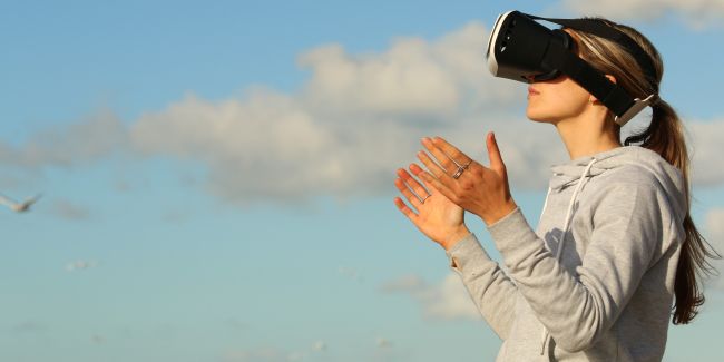 Woman using VR goggles outdoors