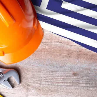 Greece flag and some construction tools on wooden background