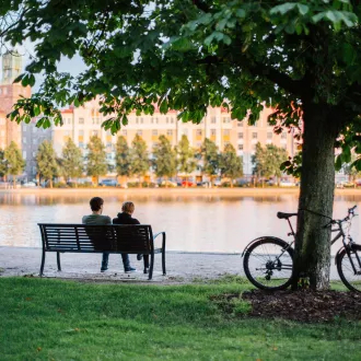 People sitting on the bench by the river