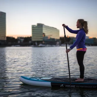 girl on sup board, city view